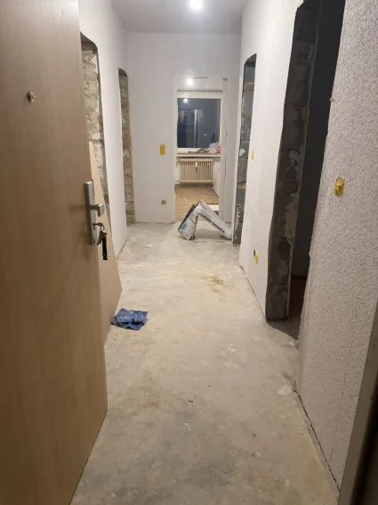 Flur beim Auszug: Türzargen ausgebaut, Estrich offen.